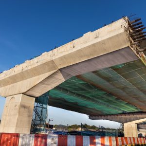 Construction of highway overpass bridge infrastructure in progress with morning sun rays